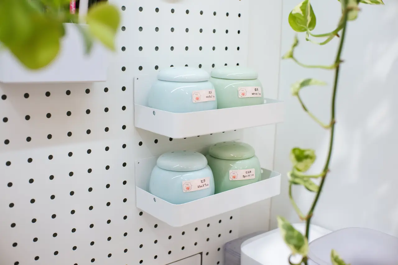 Pastel tea jars surrounded by hanging green plants